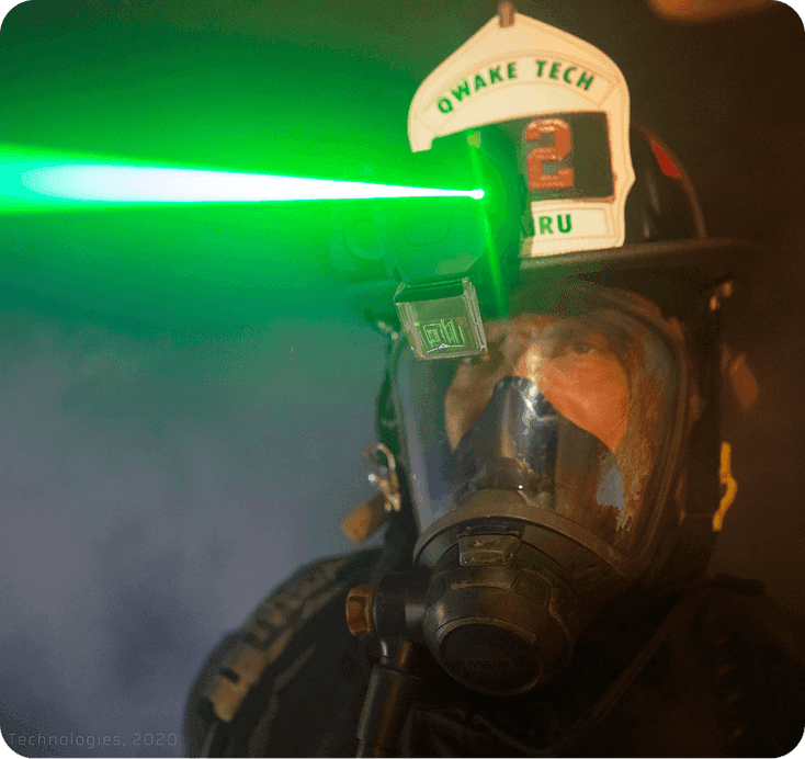 A firefighter's helmet-mounted Navigator display projecting a green targeting beam through smoke